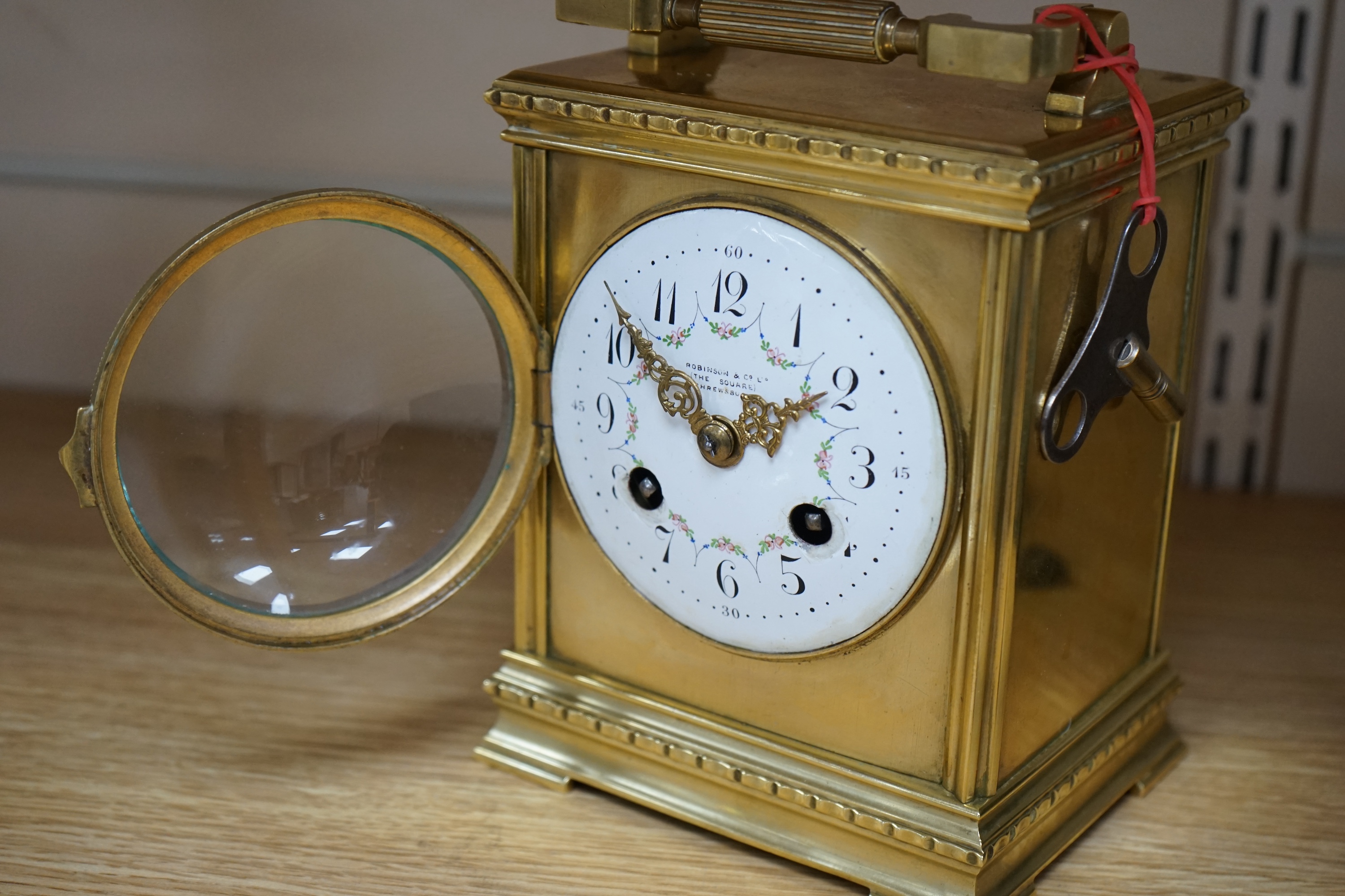 A late 19th century French brass large carriage clock with convex enamel dial, retailed by Robinson & Co. with key, 17cm. Condition - fair to good, not tested as working